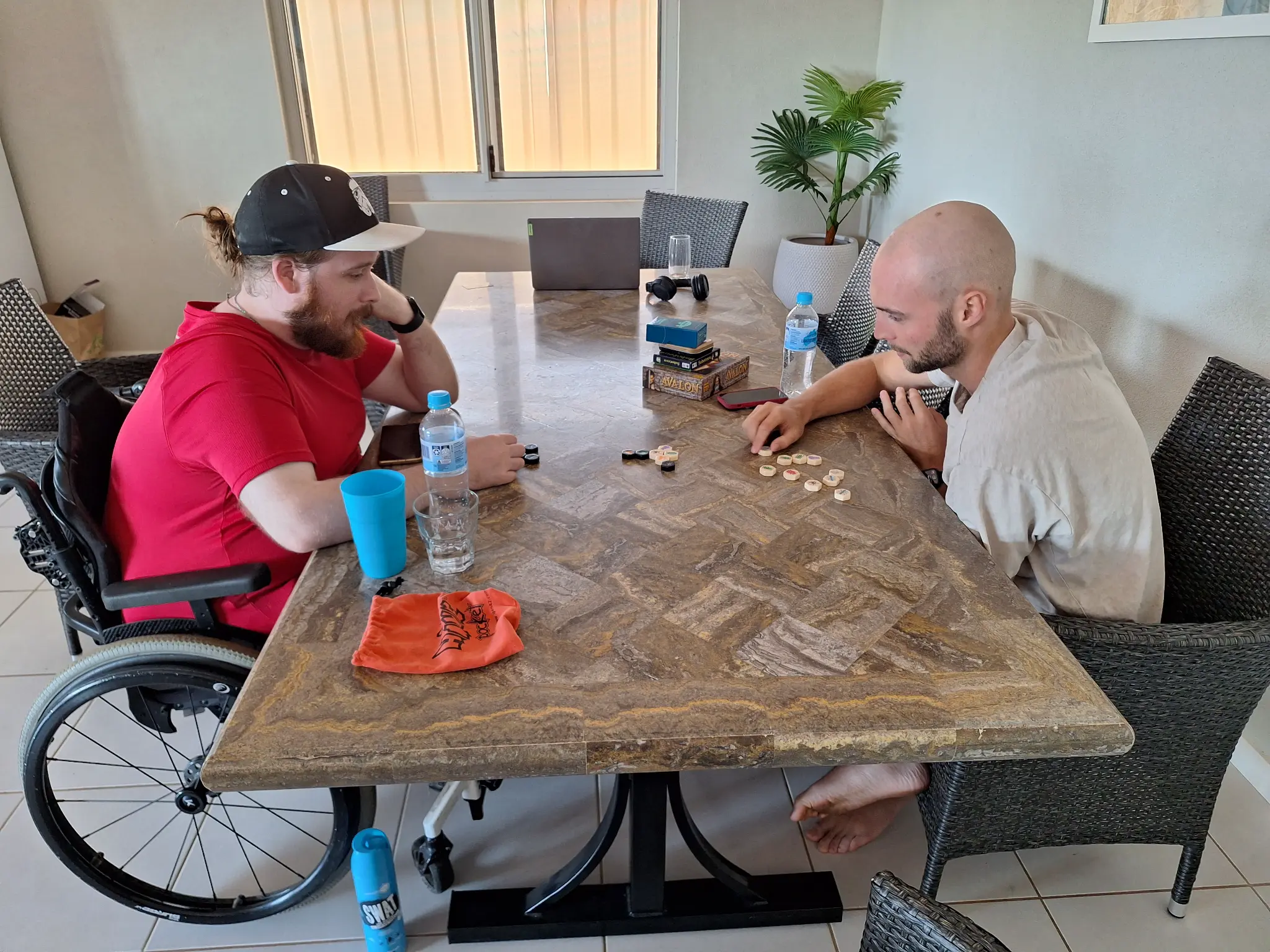 An adult participant and a familiar Happiness Crew member sharing a tabletop activity at home.