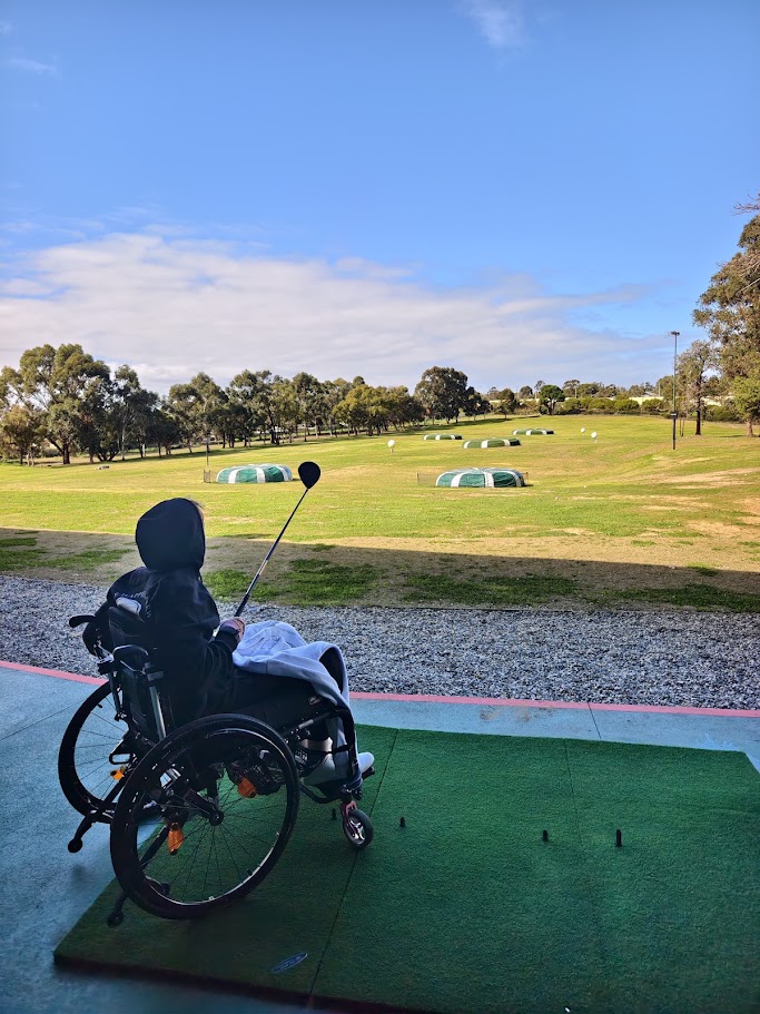 A Happiness Crew participant enjoying a golf activity in the community
