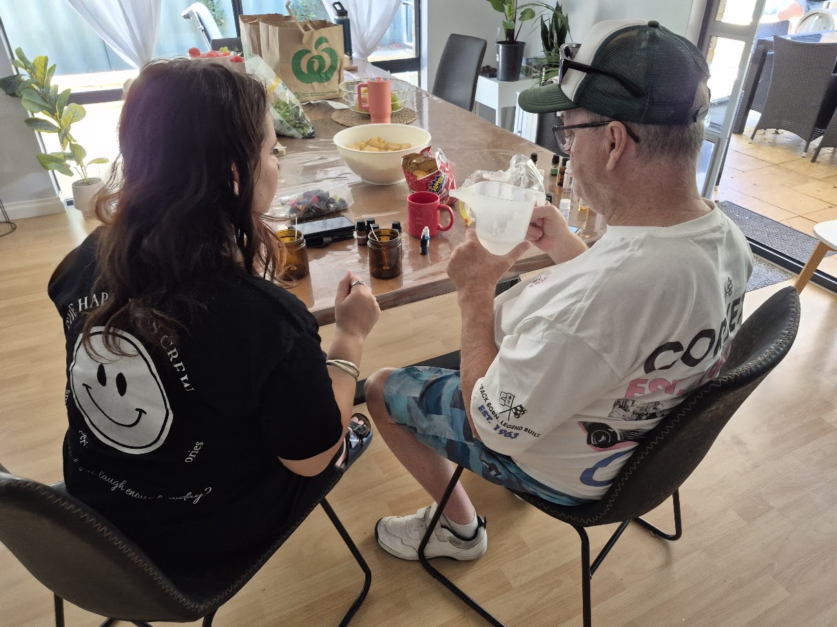 An adult participant and a Happiness Crew member sharing a hands-on activity at the table.
