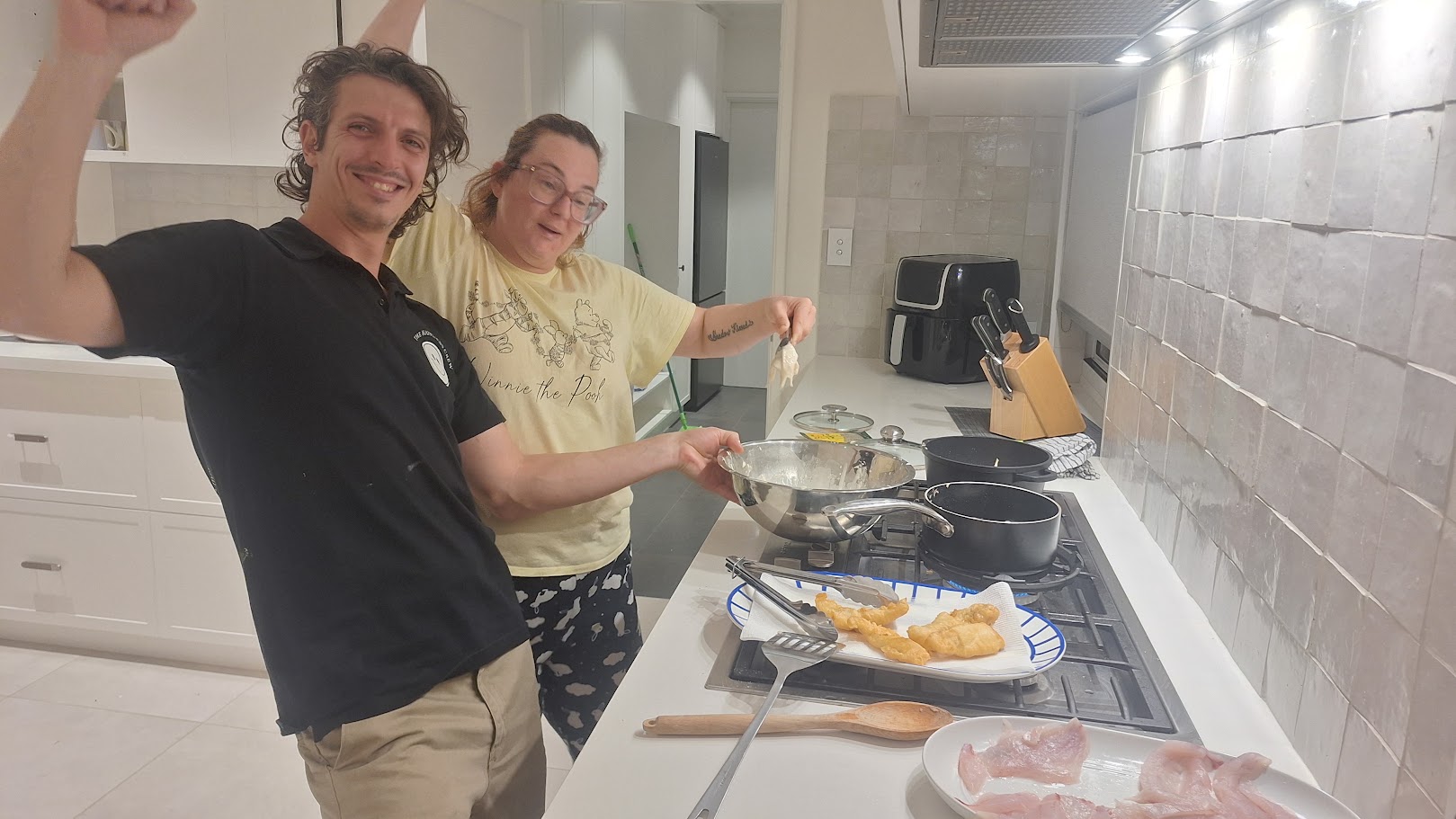 An adult participant cooking at home alongside a familiar Happiness Crew member.