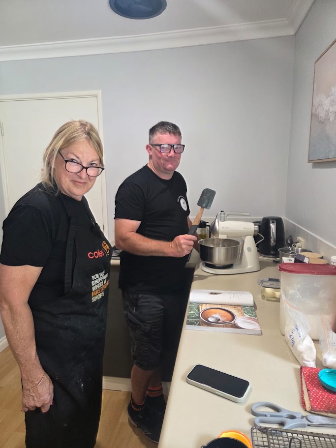 Two people preparing food together in a home kitchen